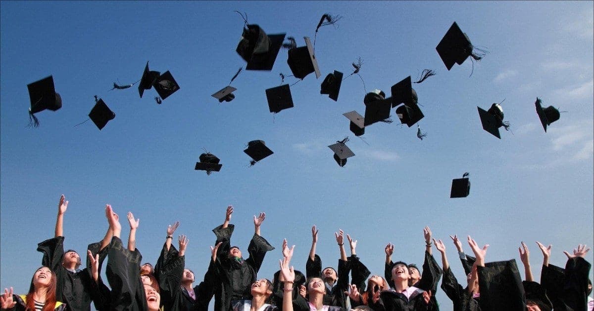 Estudantes de capa e batina a lançar os capelos ao ar