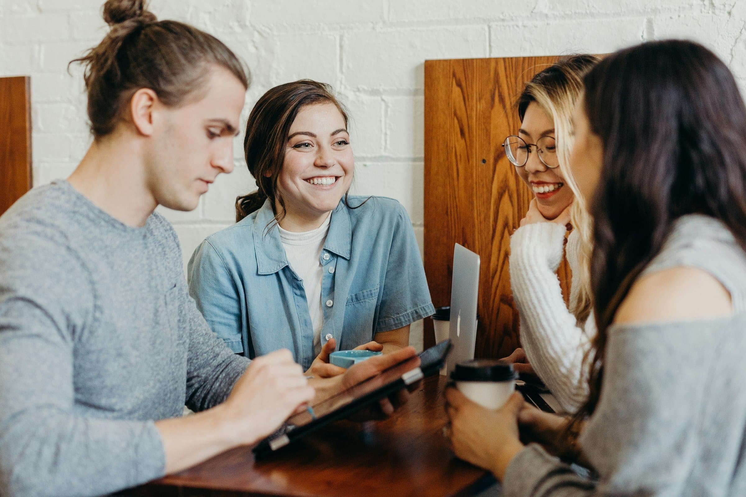Quatro jovens a estudar juntos à volta de uma mesa